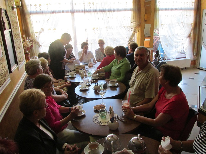 Wnętrze restauracji, przy stolikach siedzą członkowie DKK UTW wspólnie omawiają książki M. Gutowskiej-Adamczyk "Cukiernia pod Amorem" oraz W. Radziwinowicza "Gogol w czasach Google'a".