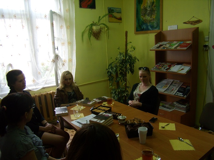 Wnętrze biblioteki, przy stoliku siedzą członkinie DKK ZS Malinowo wspólnie omawiają książkę Antoniny Kozłowskiej "Kukułka".