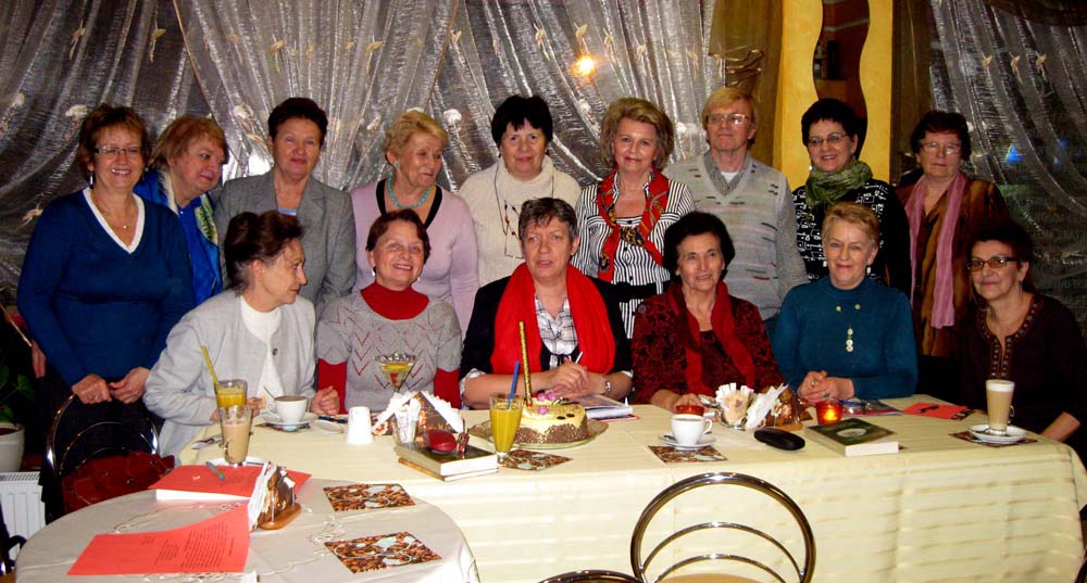 Przy stoliku siedzą członkowie DKK UTW świętują swój pierwszy rok istnienia.