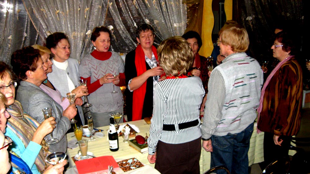 Przy stoliku siedzą członkowie DKK UTW świętują swój pierwszy rok istnienia.