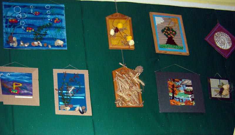 Na ścianie wisi dziewięć prac plastycznych wykonanych przez DPS z Uzdowa.