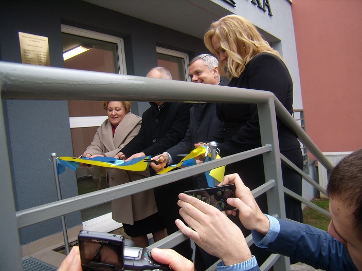 Dyrektor Justyna Lytvyn i burmistrz przecinają wstęgę na otwarcie nowej siedziby MBP.