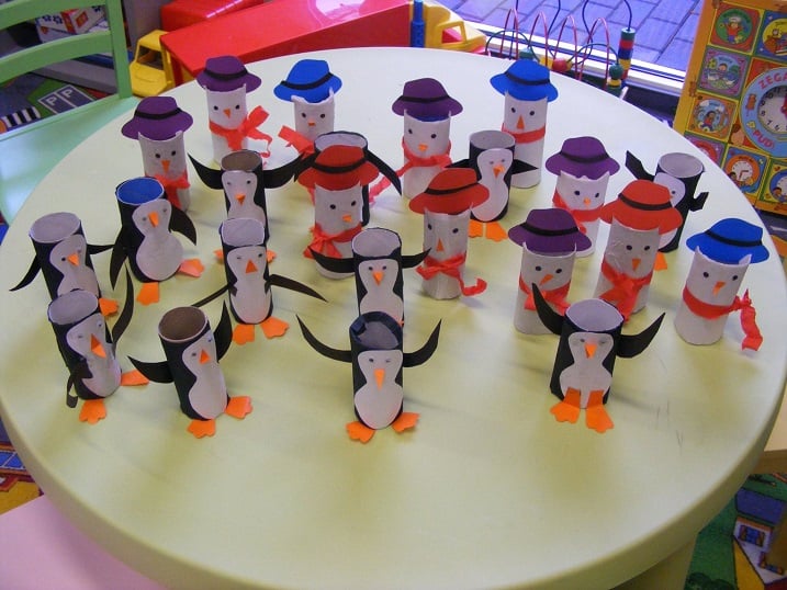 Na stoliku stoją bałwanki i pingwiny wykonane przez dzieci z rolek po papierze toaletowym.