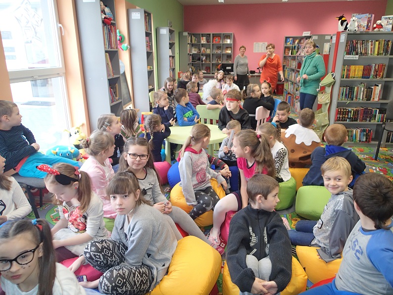 Grupa dzieci z bibliotekarkami podczas zakończenia ferii w bibliotece.