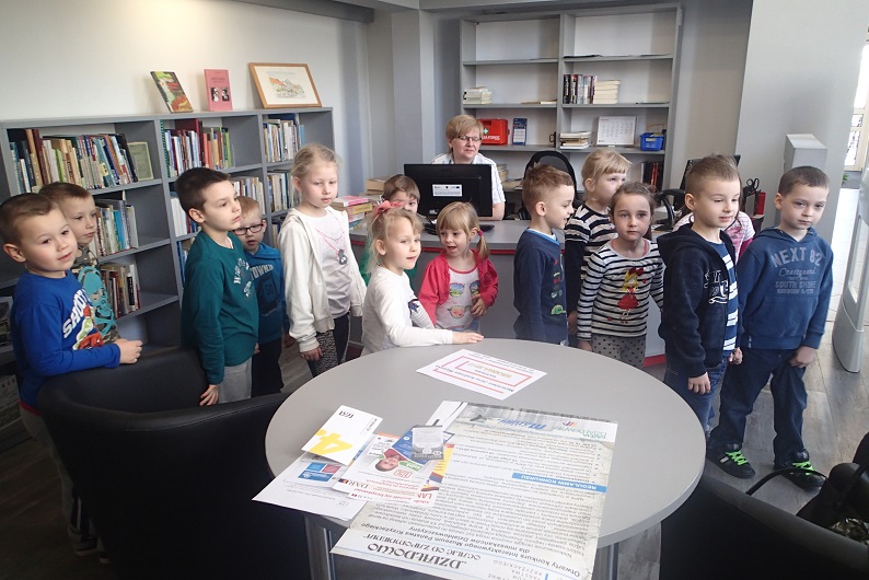 Grupa przedszkolaków zwiedza oddział dla dorosłych w bibliotece.