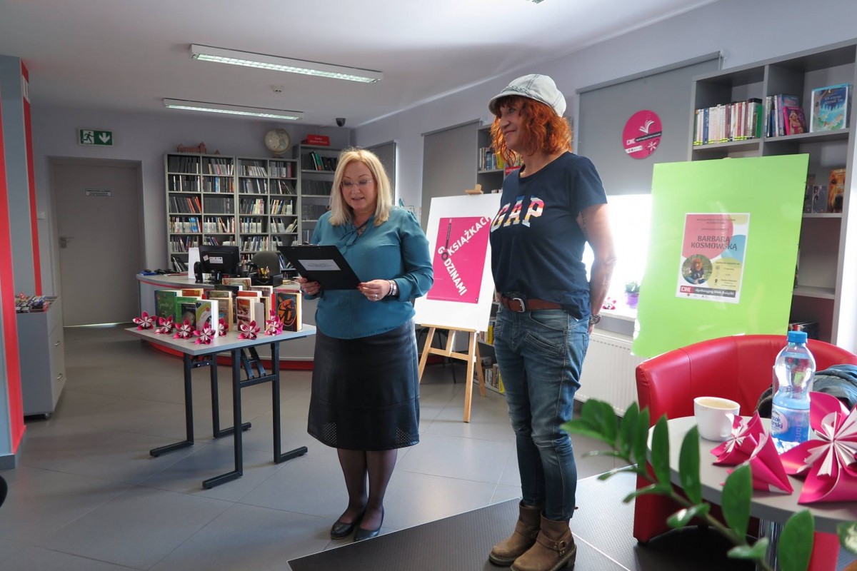Wnętrze biblioteki,mediateka. Dyrektor MBP Justyna Lytvyn przedstawia gościom autorkę  książek Barbarę Kosmowską. 