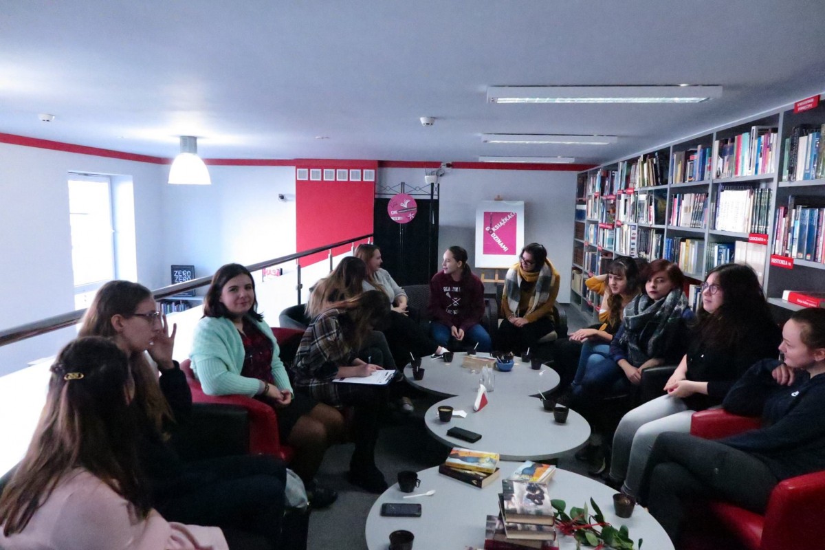 Wnętrze biblioteki. Na fotelach siedzą uczestniczki DKK ZS Malinowo i omawiają książkę "Własny pokój" Barbary Ciwoniuk. 