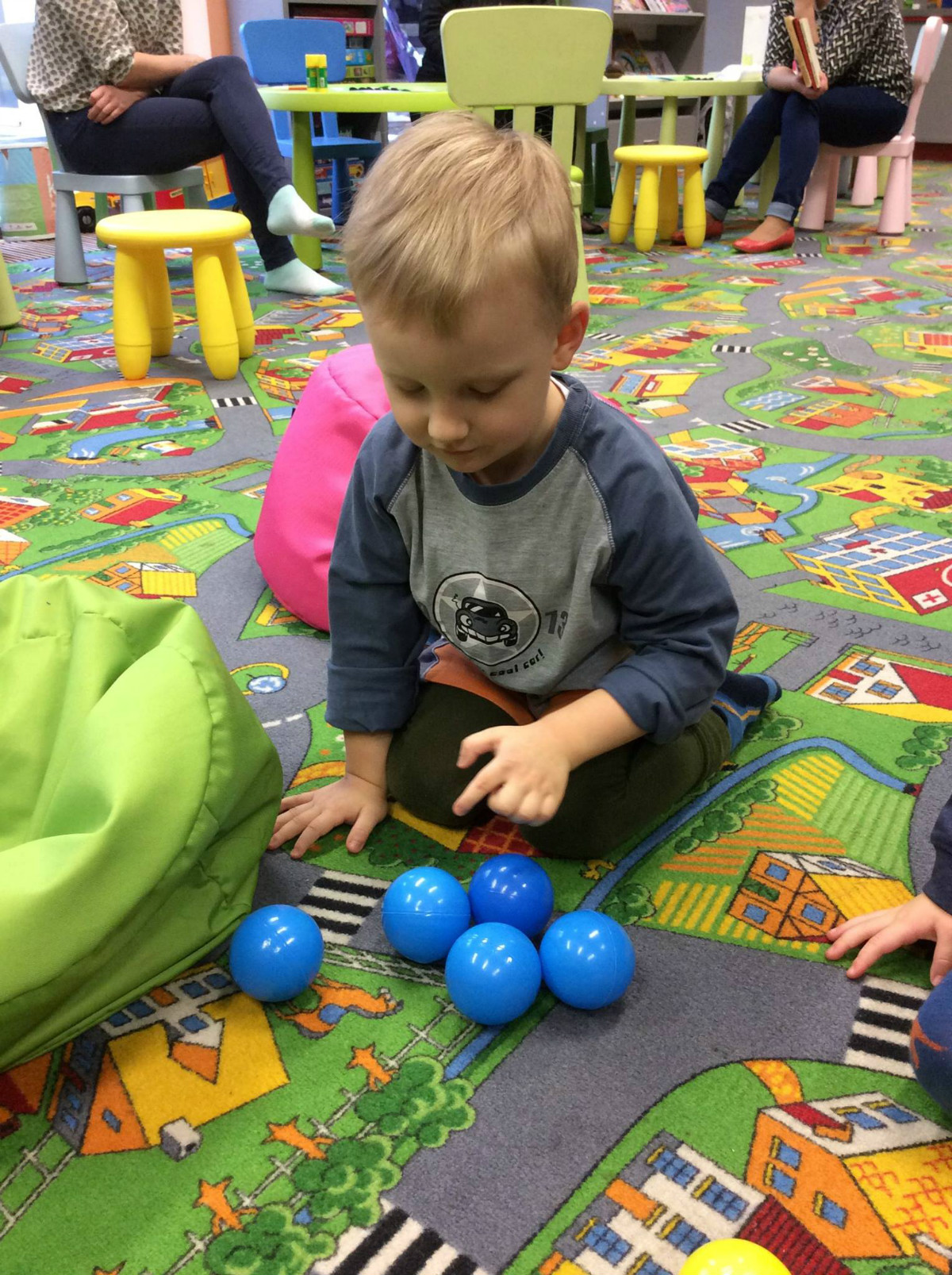Chłopiec bawi się piłeczkami w oddziale dla dzieci.