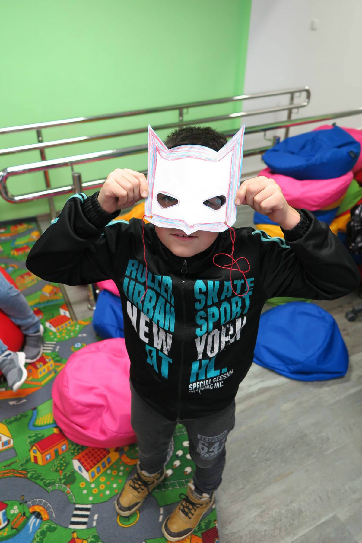 Dzieci trzymają swoje karnawałowe maski. 