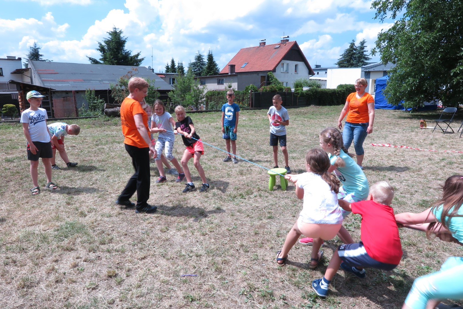 Na placu zabaw przed MBP w Działdowie bawią się dzieci w przeciąganie liny.