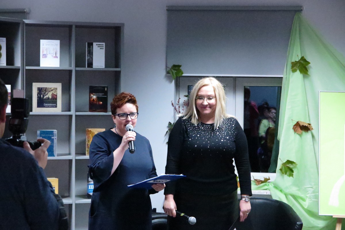 Wnętrze biblioteki,mediateka.  Przy mikrofonie prezes DKS Renata Buczyńska i dyrektor MBP Justyna Lytvyn. 
