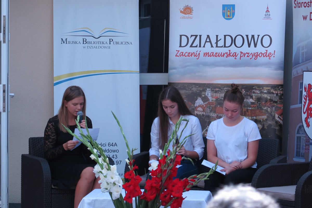 Na kanapie przed MBP w Działdowie trzy młode dziewczyny czytają powieść ,,Przedwiośnie''.