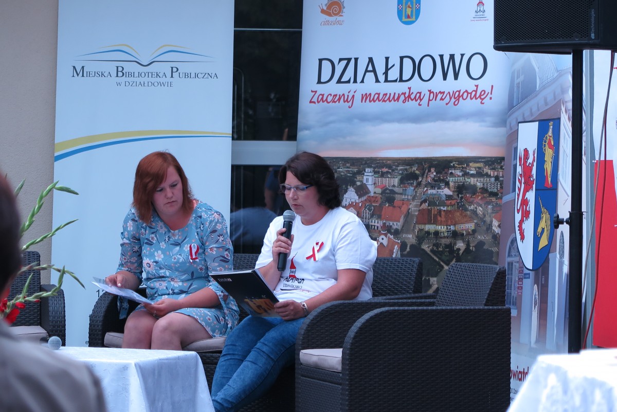 Na kanapie przed MBP w Działdowie dwie panie czytają powieść ,,Przedwiośnie''.