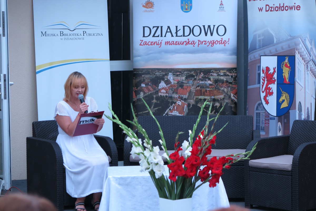 Na fotelu przed MBP w Działdowie młoda kobieta  czyta powieść ,,Przedwiośnie''.