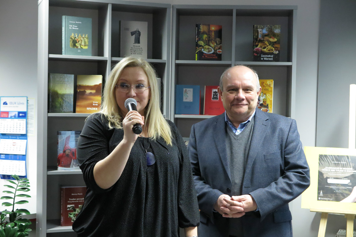 Wnętrze biblioteki, z mikrofonem dyrektor MBP Justyna Lytvyn i gość Waldemar Mierzwa.