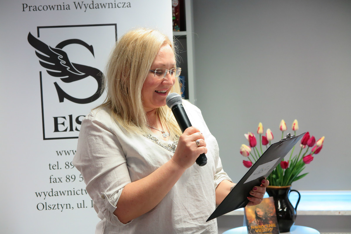 Z mikrofonem dyrektor MBP Justyna Lytvyn przedstawia autorkę książek  Panią Joanne Żamejć. 