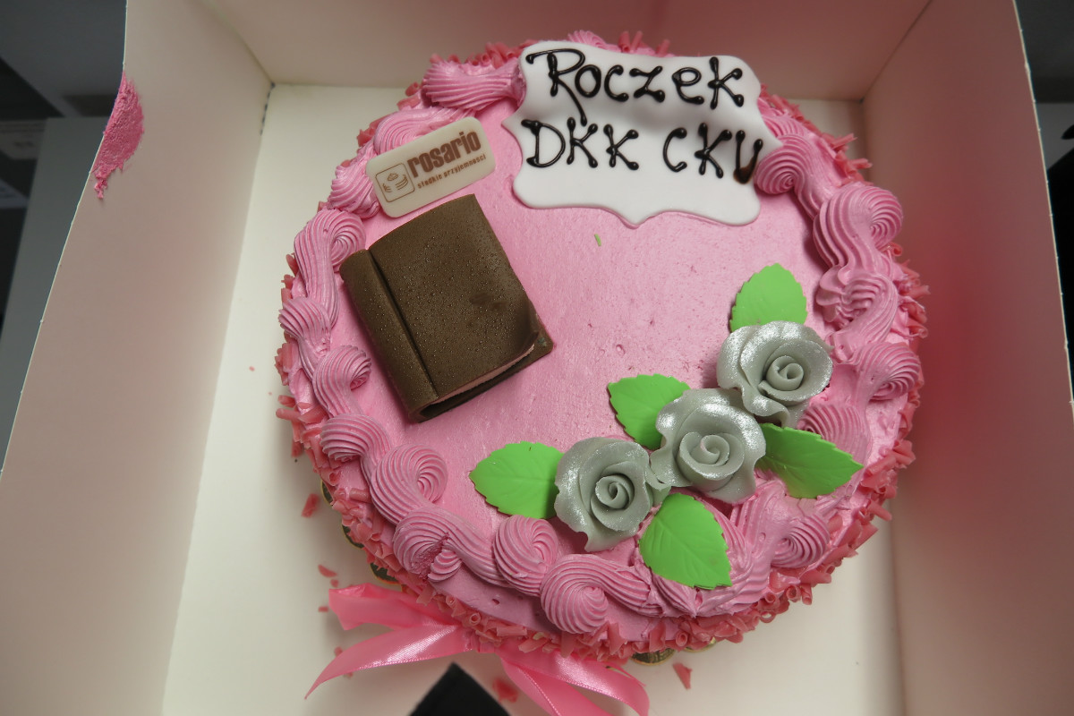 Różowy tort z napisem "Roczek DKK CKU''.