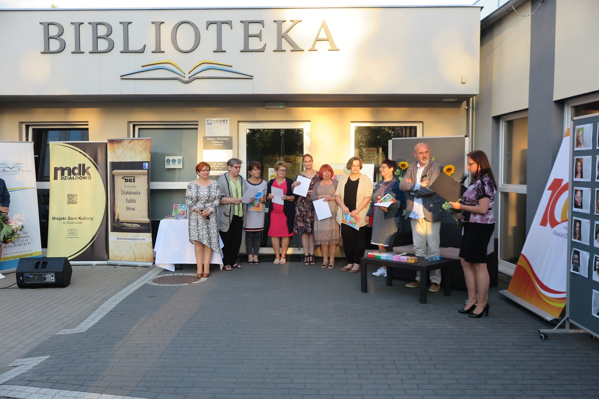 Na placu przed biblioteką aktor Marcin Troński oraz goście biorący udział w spotkaniu poezji.