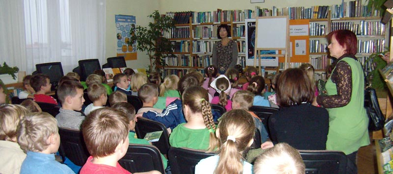 Wnętrze biblioteki. Na krzesełkach siedzi młodzież zgromadzona na spotkanie z Izabellą Klebańską, absolwentką Akademii Muzycznej w Łodzi, autorką wielu książek dla dzieci popularyzujących muzykę.
