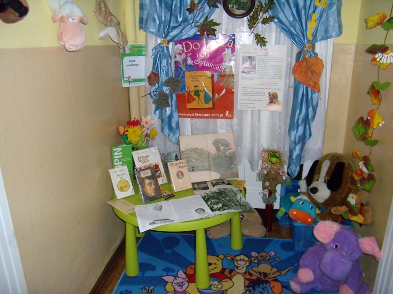 kącik w bibliotece poświęcony Szopenowi, stolik  a na nim książki, dookoła pluszowe zabawki