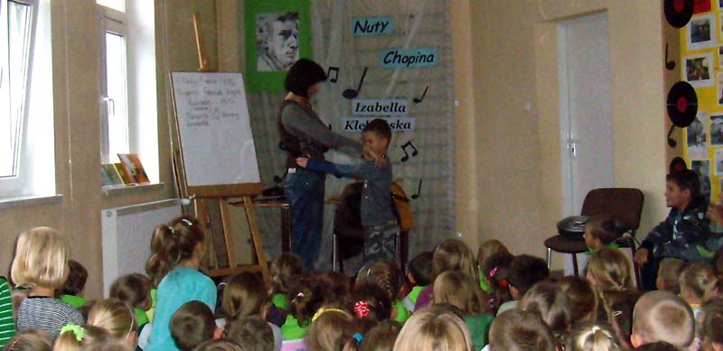 Grupa dzieci z Izabellą Klebańską podczas zajęć muzycznych.