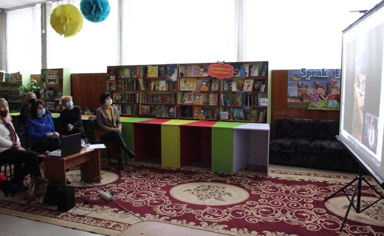 Wnętrze biblioteki na Ukrainie. Na ekranie wyświetlana jest telekonferencja.
