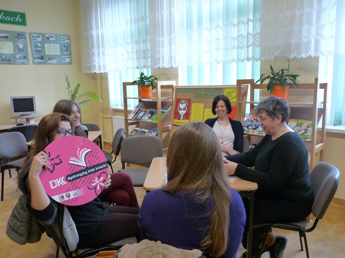 Przy stoliku siedzi pani Ewa Sotomska i członkinie DKK GIM NR 1 wspólnie omawiają  książkę J. Korczaka  "Pamiętnik i inne pisma z getta".  