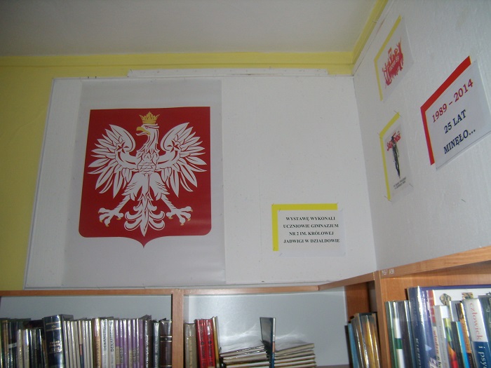 Na ścianie wisi flaga z Godłem Rzeczypospolitej Polskiej z okazji 25 rocznicy obrad do Sejmu i Senatu.