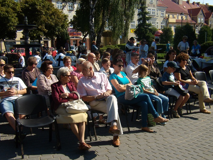 Na krzesełkach siedzą goście zebrani na narodowe czytanie ''Trylogii'' H. Sienkiewicza.