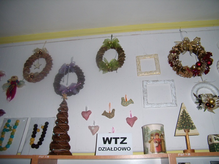 Na ścianie wiszą prace uczestników Warsztatów Terapii Zajęciowej w Działdowie.