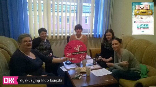 Wnętrze CKU. Przy stoliku siedzą uczestniczki DKK wspólnie omawiają książkę Szymona Hołowni "Ludzie na walizkach".
