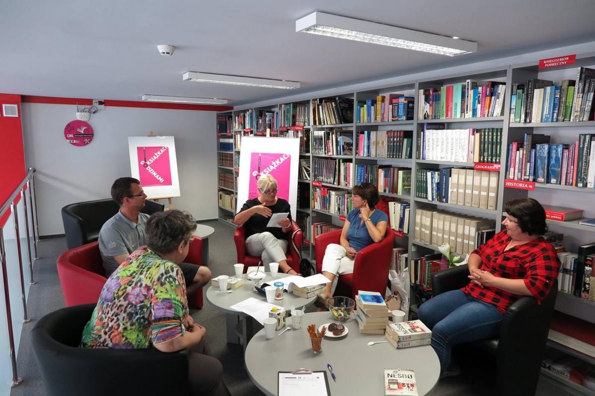 Wnętrze biblioteki. Na czerwonych fotelach siedzą uczestnicy DKK i dyskutują o książce Jo Nesbo pt." Syn".
