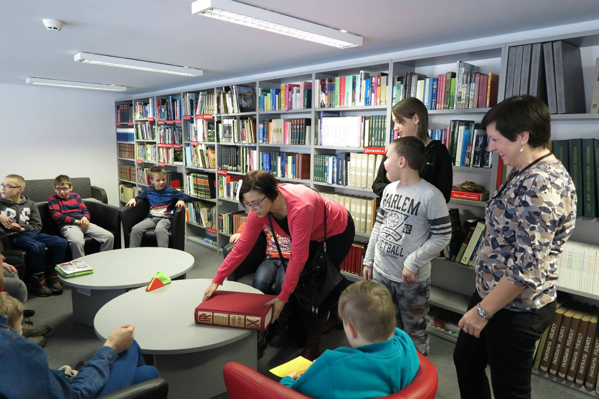 Wnętrze biblioteki. Grupa z OREW podczas zajęć edukacyjnych w bibliotece. 