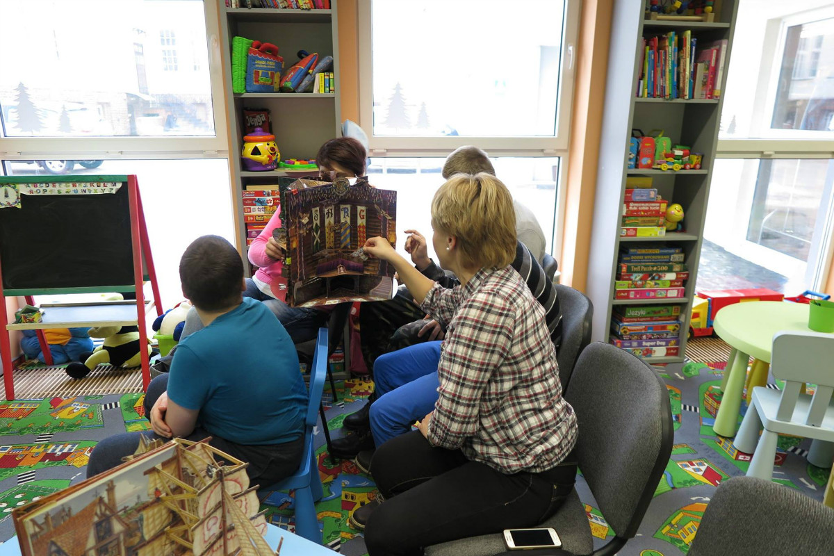 Wnętrze biblioteki. Grupa młodzieży z OREW podczas zajęć edukacyjnych w oddziale dla dzieci.