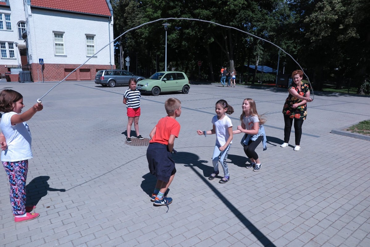Na placu przed MBP dzieci skaczą przez skakankę.
