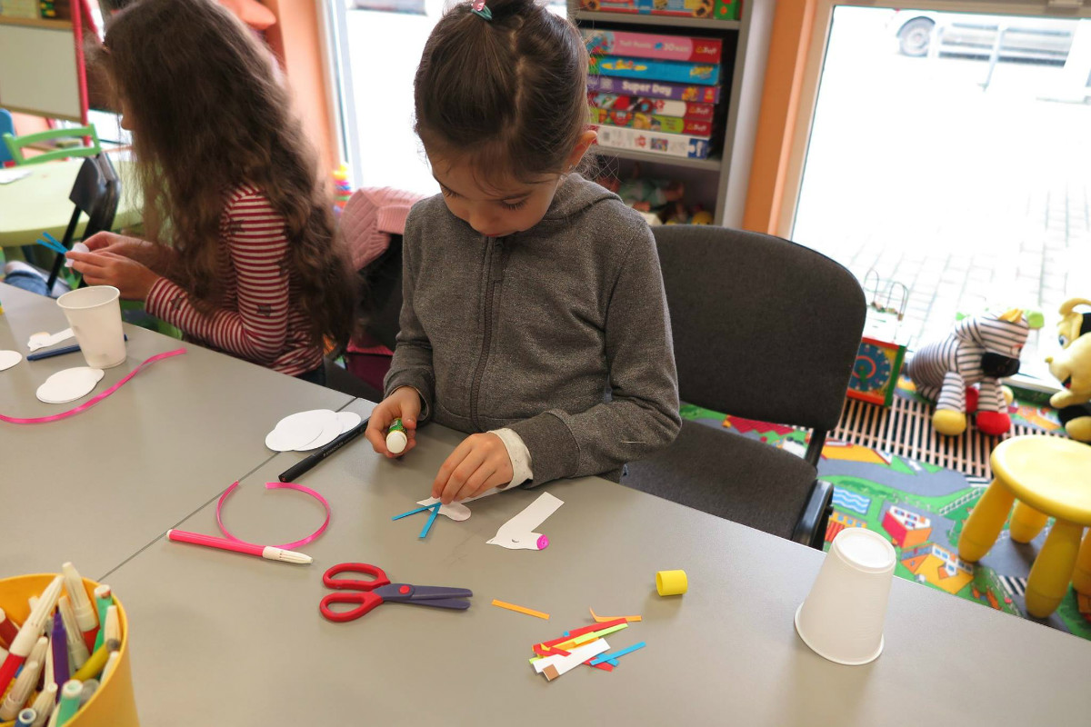 Przy stoliku dzieci wykonują prace plastyczne kartki walentynkowe oraz jednorożce z wcześniej przygotowanych elementów.