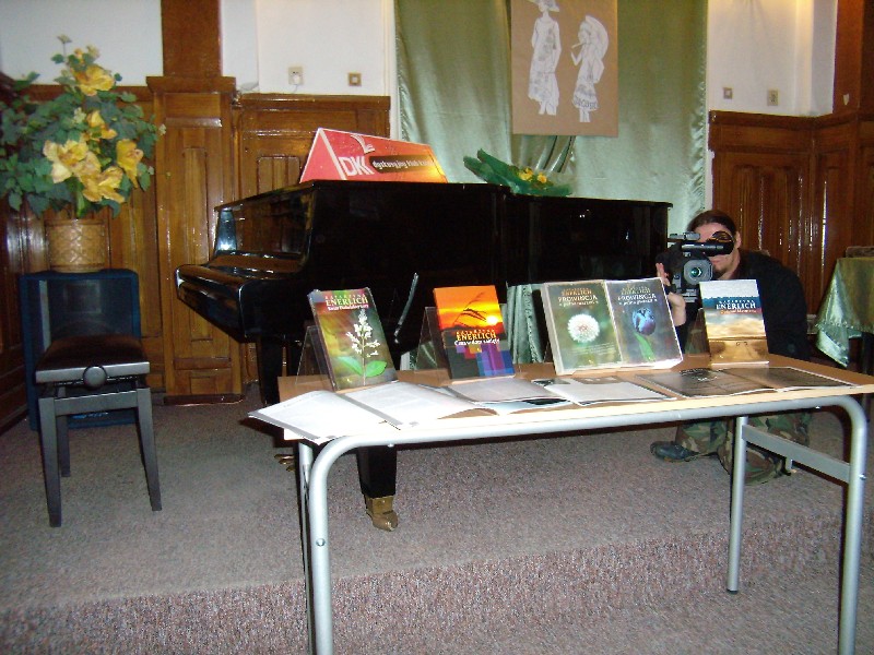 Na scenie w szkole muzycznej fortepian i stolik na którym znajdują się książki pisarki Katarzyny Enerlich.