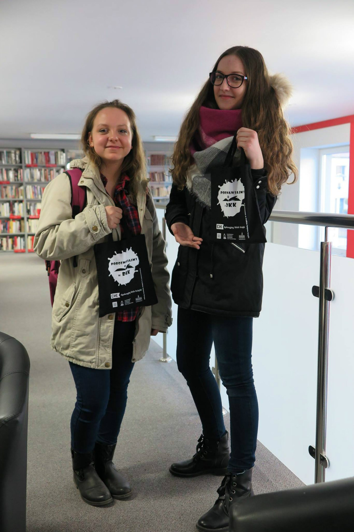 Dwie uczestniczki z DKK SP nr 1 z czarnymi torebkami z napisem ''Porozmawiajmy o książkach DKK''.