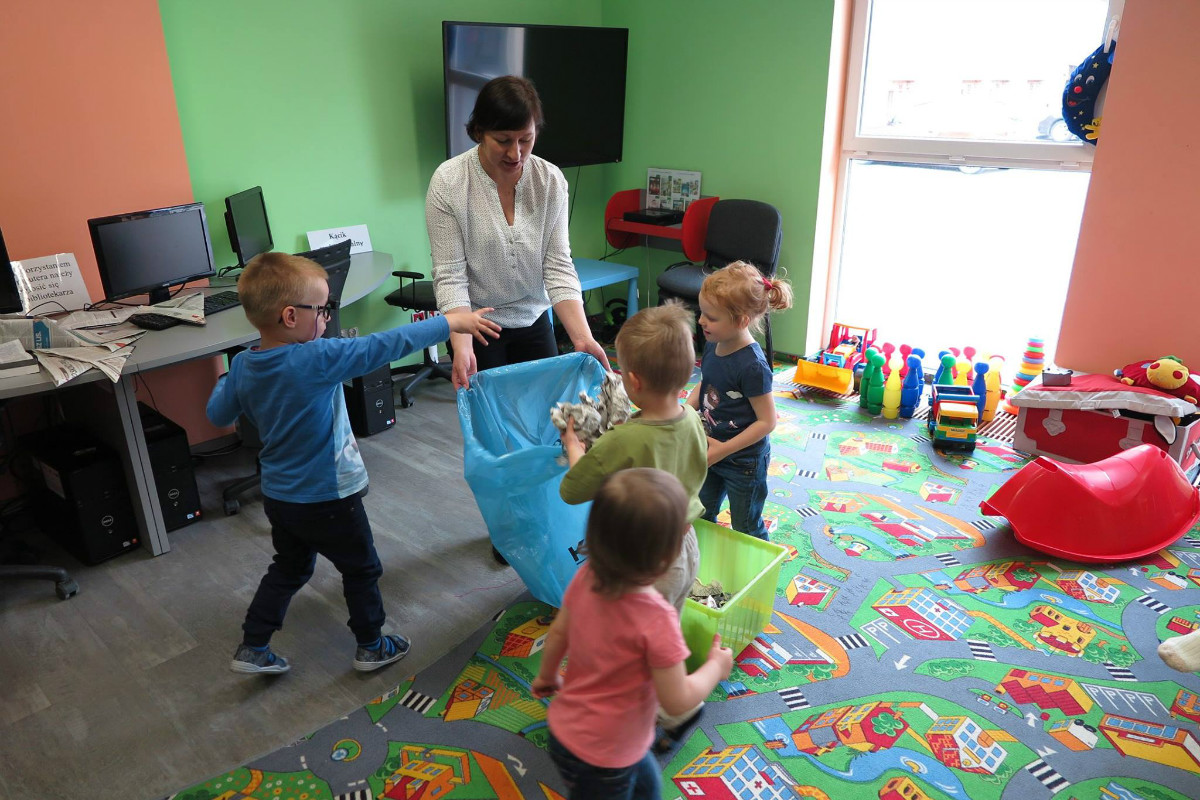 Dzieci z bibliotekarką Anią Wiśniewską podczas zajęć w oddziale dla dzieci.