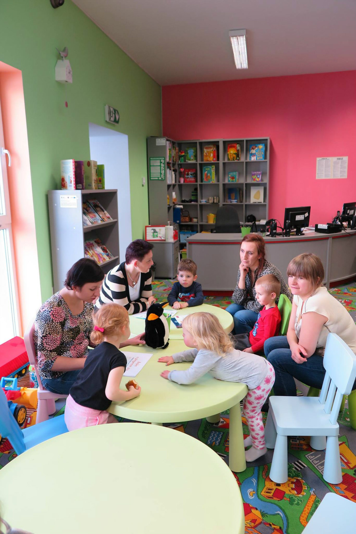 Przy stolikach siedzą dzieci z opiekunkami, bibliotekarka Ania Wiśniewska czyta opowiadanie o Kamyczku i jego mamie. 