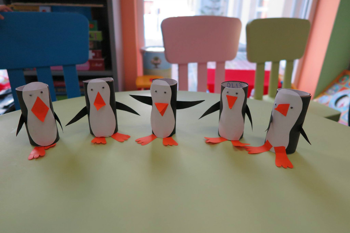 Na stoliku stoi 5 pingwinów zrobionych z rolek papieru. 