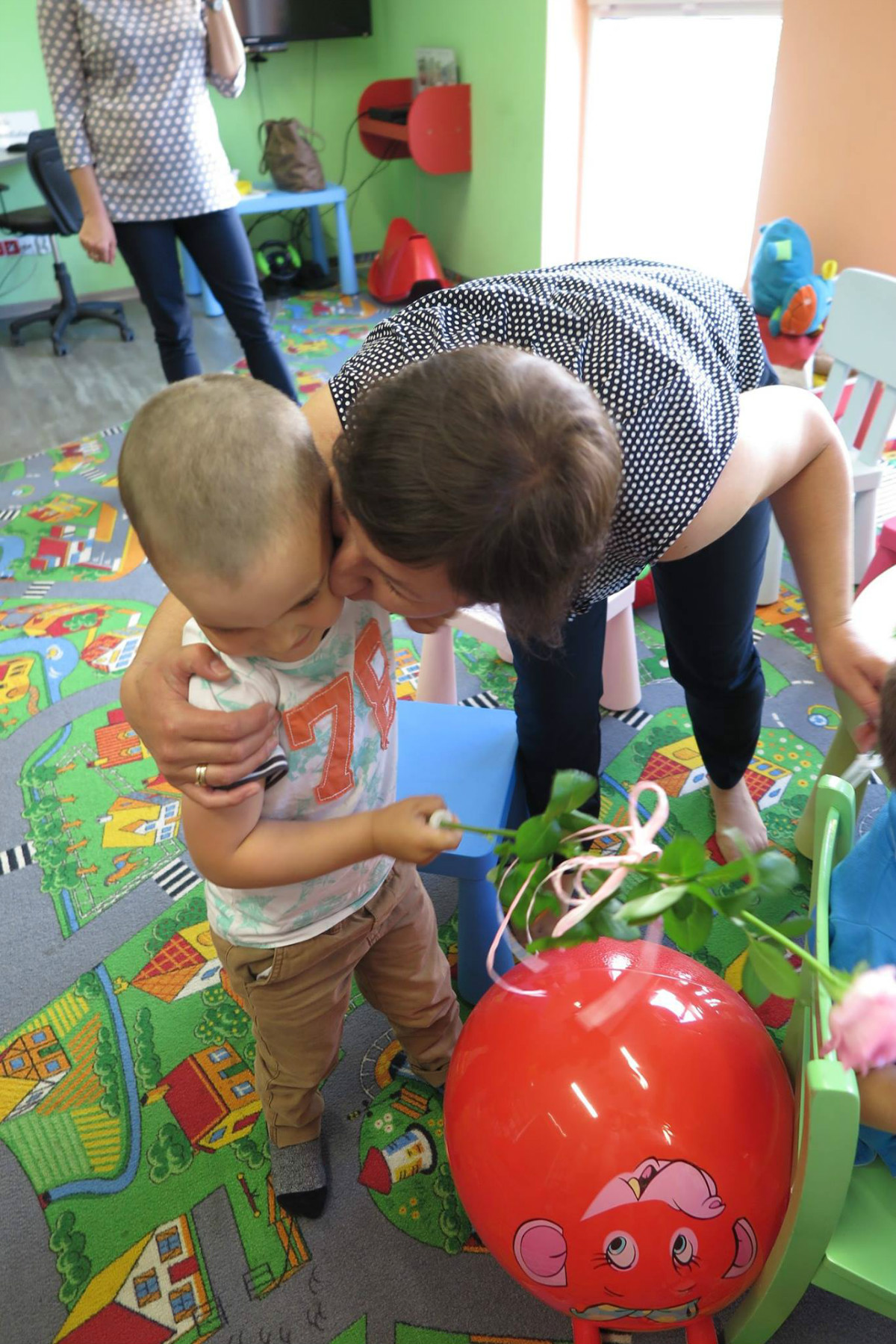 Bibliotekarka Ania Wiśniewska składa uściski chłopcu z okazji zakończenia roku w klubie malucha. 