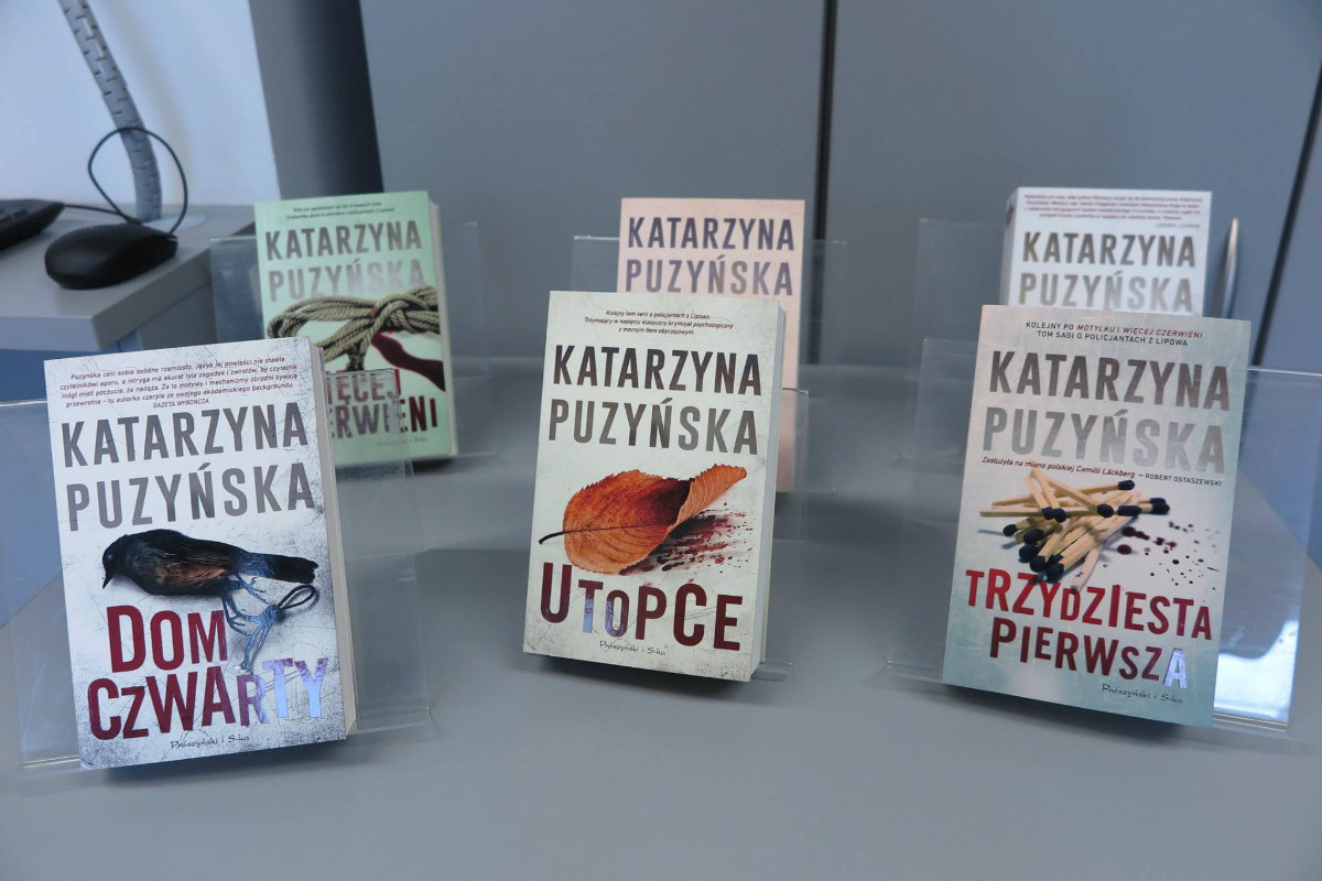 Na stoliku książki autorki Katarzyny Puzyńskiej.