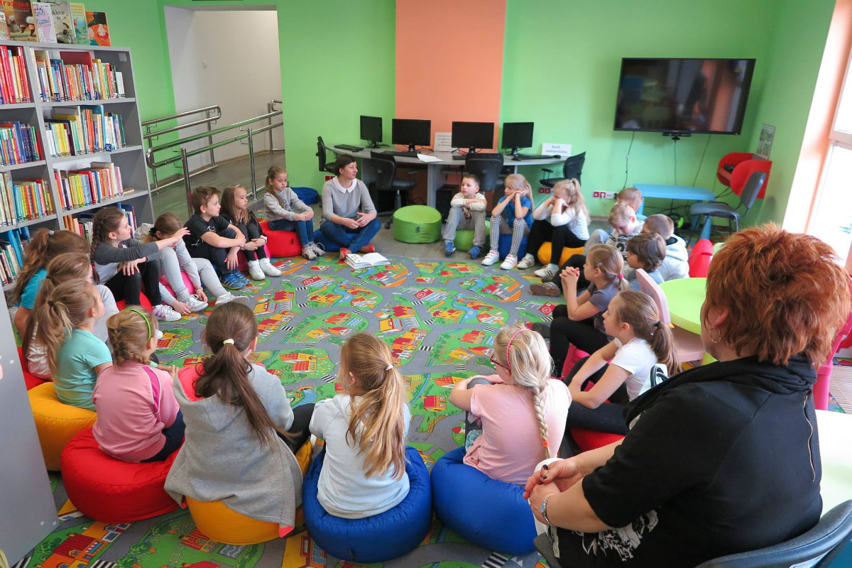 W kole siedzą dzieci, bibliotekarka Ania Wiśniewska prowadzi zajęcia na temat wartości.