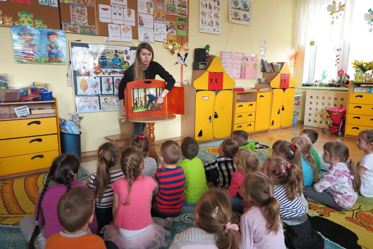 Wnętrze Przedszkola nr 1 , grupa dzieci z bibliotekarką Aleksandrą Cybulską słucha teatrzyku.