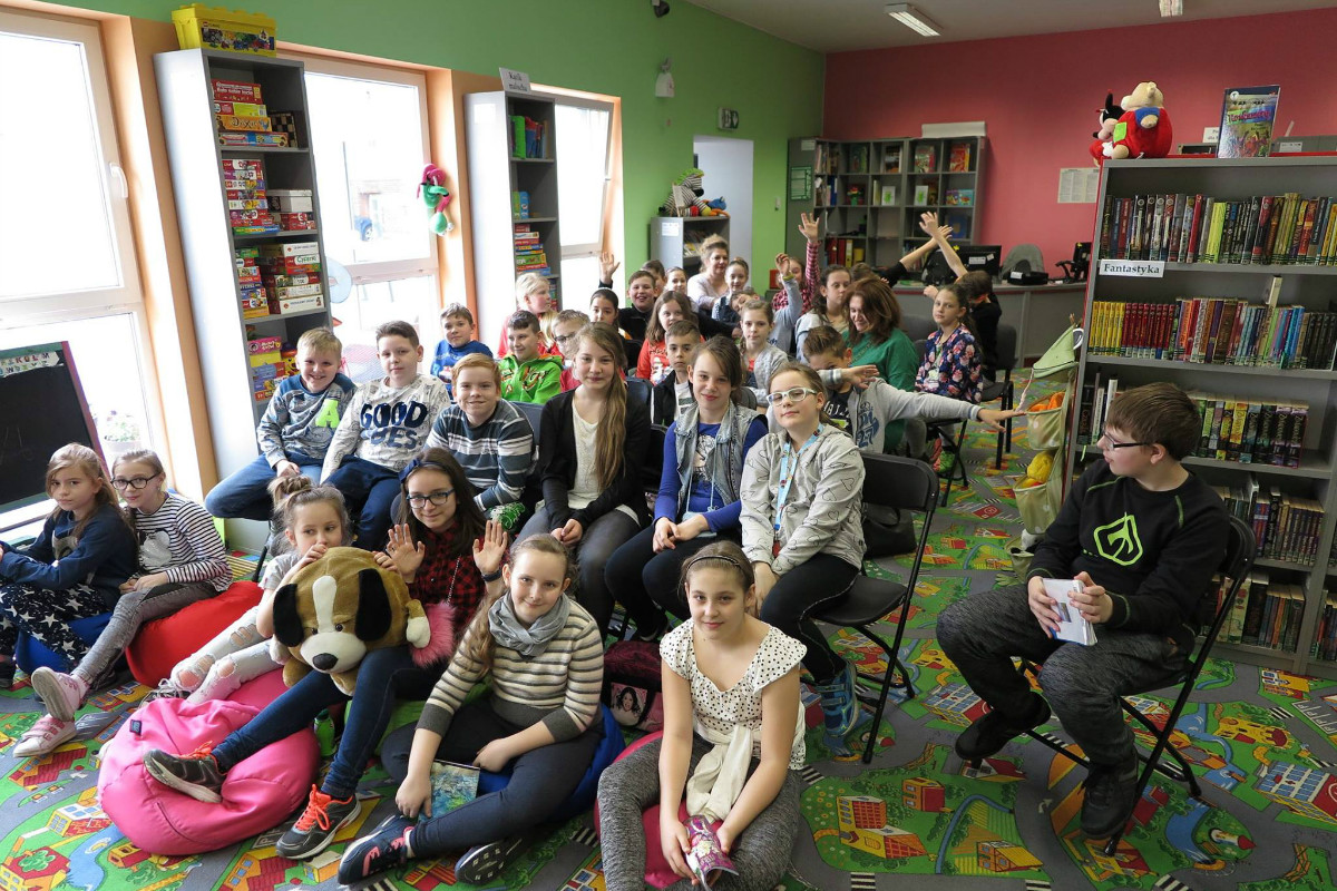 Grupa dzieci bierze udział w zajęciach z autorką Elżbietą Zubrzycką. 