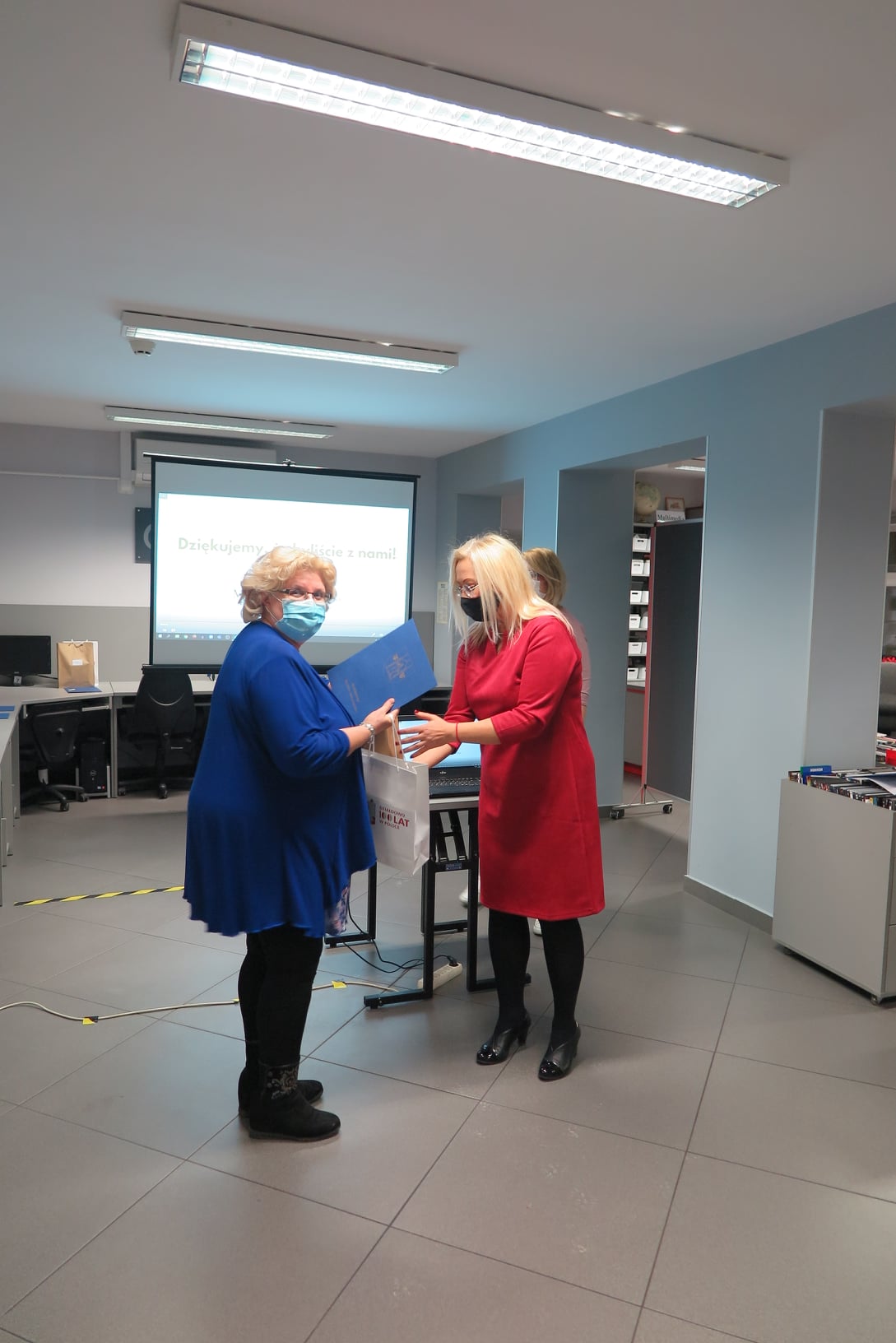 Dyrektor biblioteki Justyna Lytvyn wręcza dyplom oraz nagrodę laureatce, która wysłuchała najwięcej audiobooków w roku 2020.