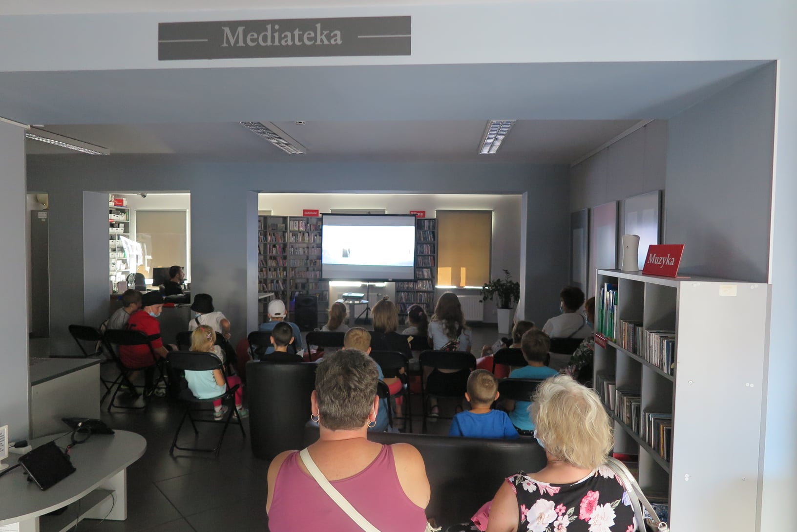 Seans bajkowy, grupa 24 dzieci (kilka osób dorosłych) oglądają bajkę w Mediatece.