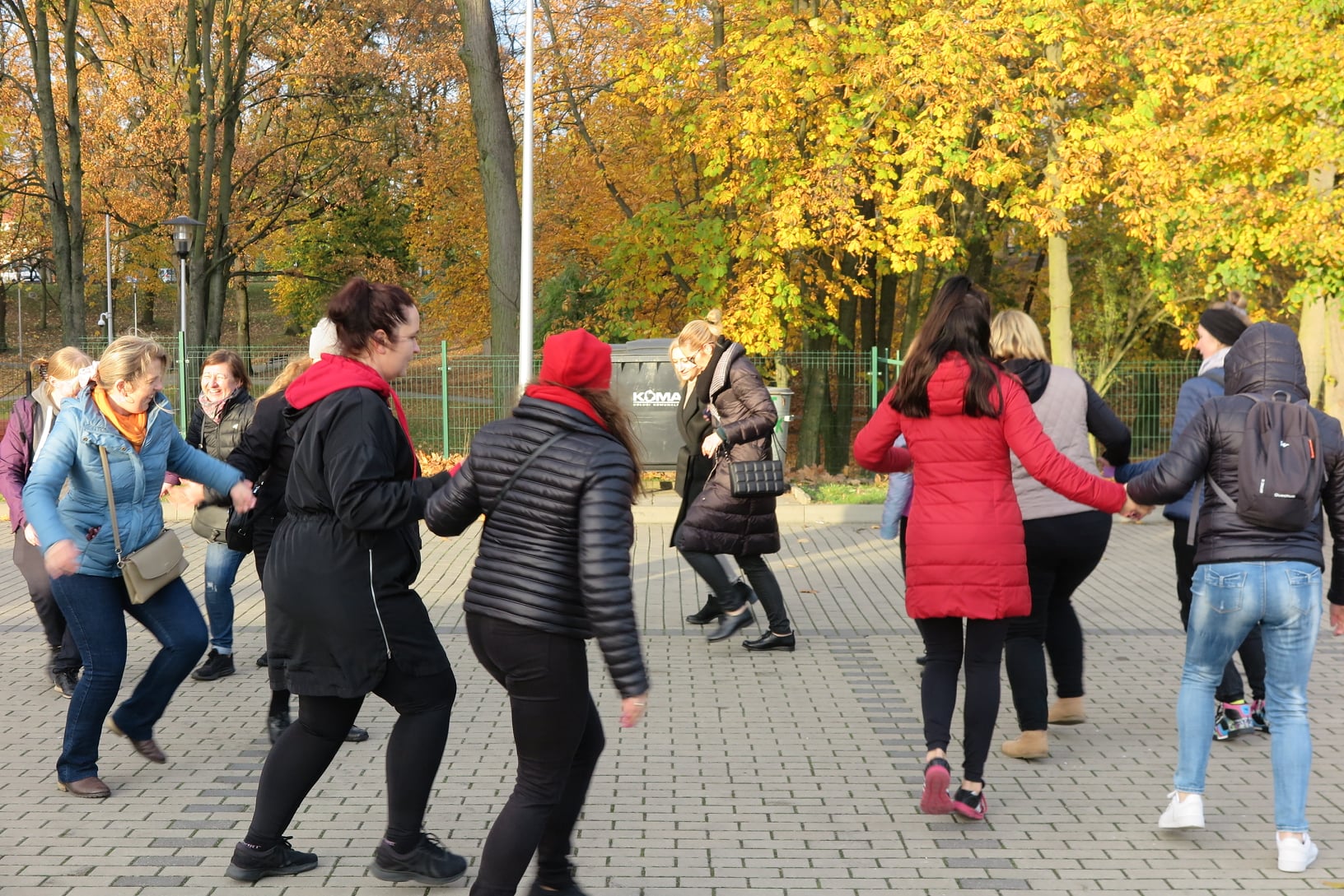 grupa osób tańczy na placu