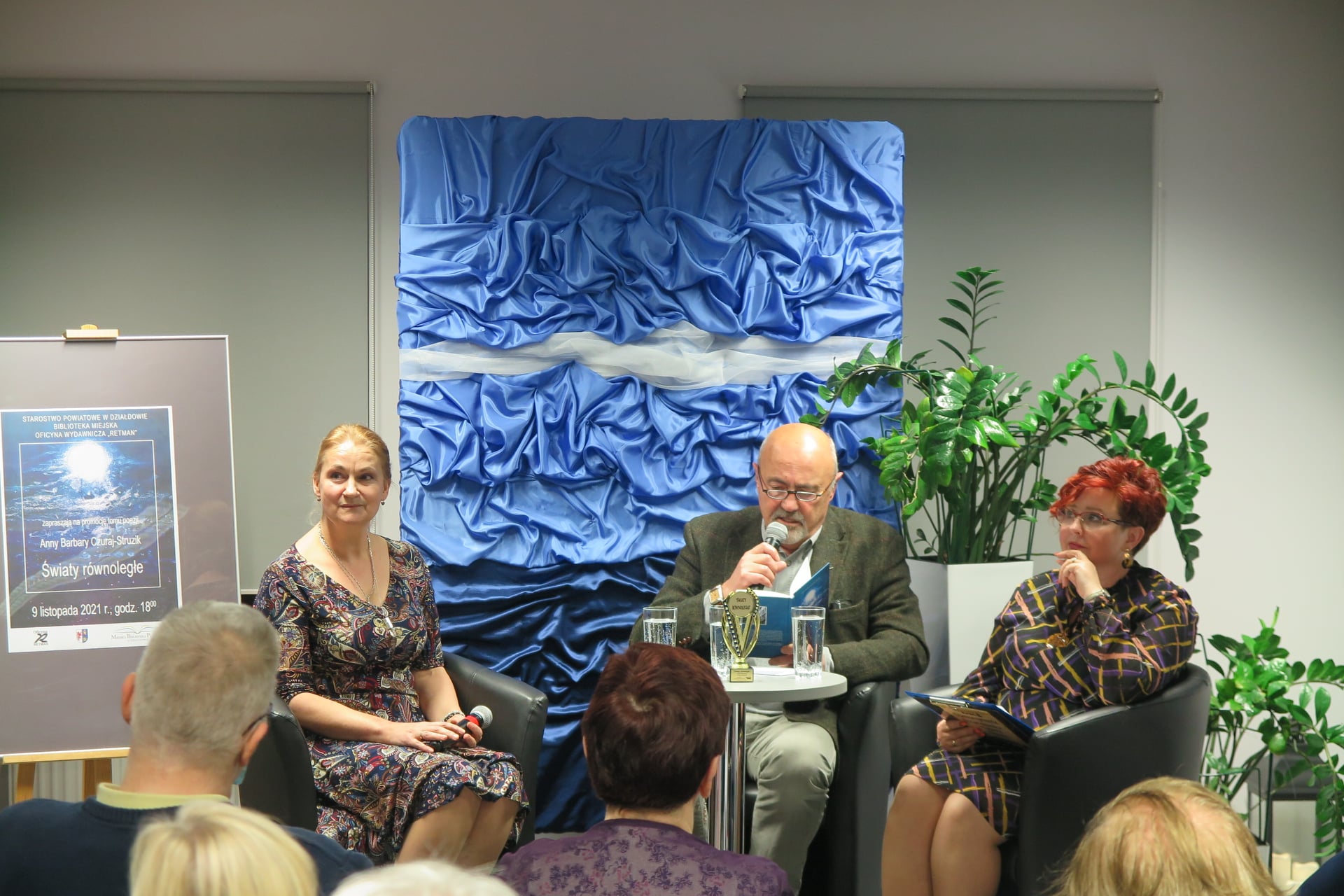 na scenie siedzą w fotelach Anna Barbara Czuraj-Struzik, Marcin Troński, Renata Buczyńska, Marcin Troński czyta do mikrofonu wiersze